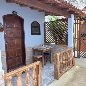 a porch with a wooden door and a table at residência móvel em marica in Maricá