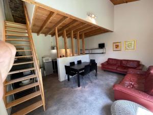 un soggiorno con un divano rosso e un tavolo di Dordogne et Corrèze vacances - Gites a Troche