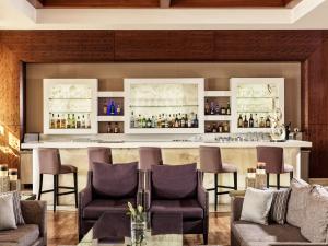 a bar in a hotel room with chairs and a counter at Atlantica Aphrodite Hills Hotel in Kouklia