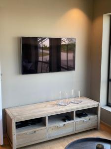 a wooden entertainment center with two wine glasses on top at Apartment with boat in Spangereid