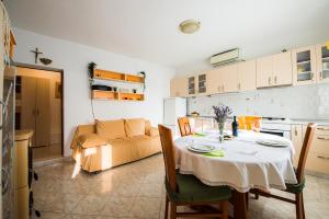 uma cozinha e sala de jantar com uma mesa e um sofá em Kuća za odmor Boris em Podstrana