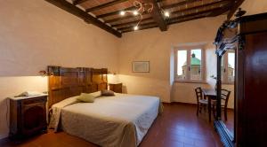 科尔托纳意大利科尔托纳酒店的一间卧室，里面有一张床、一张桌子和几把椅子。