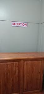 a sign that reads reception on top of a wooden desk at Thully Teams in Nelspruit