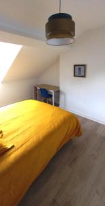 HISTOIRE DE LOIRE - LA TOUE في سوموور: سرير أصفر كبير في غرفة مع مكتب