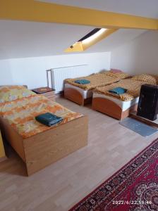 a room with three beds and a rug at Gospodarstwo Agroturystyczne U Stasików in Spytkowice