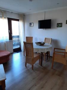 a living room with a table and chairs and a television at Ferienwohnung Bergblick - a63503 in Hallenberg