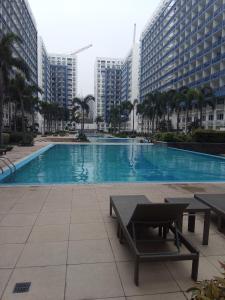 a large swimming pool in a city with tall buildings at MOA Rental in Manila