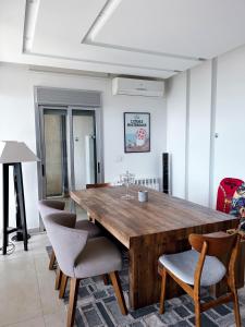 uma sala de jantar com uma mesa de madeira e cadeiras em Panoramic Sea View 2 Bedroom Apartment em Jbeil