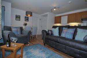 No5 Esplanade Court, Stornoway Town Centre في ستورنووي: غرفة معيشة مع أريكة وطاولة