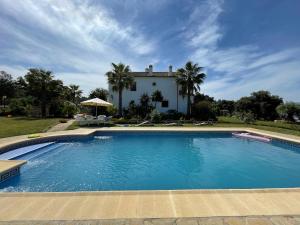 ein großer Pool vor einem Haus in der Unterkunft Finca las Encinas in Ronda