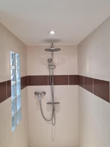 um chuveiro na casa de banho com azulejos castanhos e brancos em Entre Dordogne et Charente en Nouvelle Aquitaine em Porchères