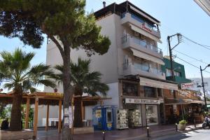 a tall white building with palm trees in front of it at Dorian Boutique Hotel-Apartments in Hersonissos