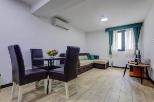 a living room with a table and chairs and a couch at Porta Volta Residence in Becici