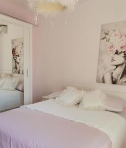 a bedroom with a white bed and a mirror at Nina in Baška Voda