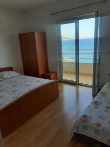 a bedroom with a bed and a view of the beach at Apartmani Karla in Dugi Rat