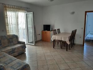 a living room with a table and chairs and a couch at Apartmani Karla in Dugi Rat