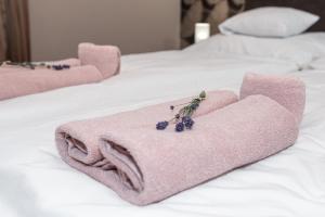 Una toalla rosa en una cama con uvas. en Ruben Vendégház en Demjén