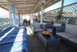 eine Veranda mit Sofas und einem Tisch mit Obst darauf in der Unterkunft Holiday Residence Rifugio in Orosei