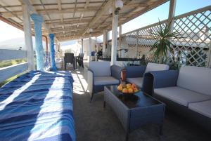 een veranda met banken en een tafel met fruit erop bij Holiday Residence Rifugio in Orosei