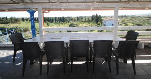 een tafel en stoelen op een veranda met uitzicht bij Holiday Residence Rifugio in Orosei
