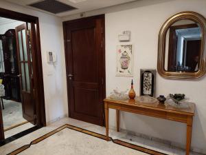 Zimmer mit einem Holztisch und einem Spiegel in der Unterkunft jolie appart au centre urbain nord in Tunis