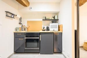 a kitchen with a stove and a microwave at LE DREZEN - Cocon tendance au port de Vannes in Vannes