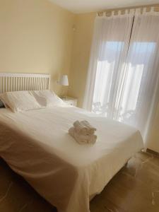 um quarto com uma cama branca e toalhas em Lambda LI em Almuñécar
