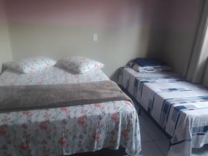 two beds in a small room with at Aluguel casa Bombinhas in Bombinhas