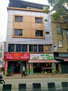 een man die door een straat loopt voor een gebouw bij S K RESIDENCY in Bangalore