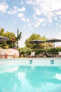 einen Pool mit Stühlen und Sonnenschirmen in der Unterkunft IADES suites in Afytos