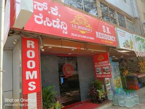 een winkel met rode borden aan de zijkant van een gebouw bij S K RESIDENCY in Bangalore