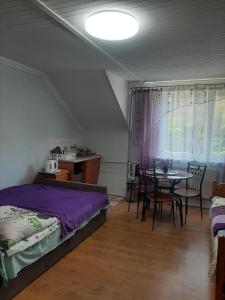 a bedroom with a bed and a table with chairs at Pokoje gościnne Cuma in Łeba