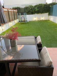 a table and chairs on a patio with a lawn at O Alecrin de Bouzas Ribeira Sacra in Pereiro de Aguiar