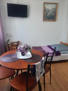 a room with a table with flowers and a bed at Pokoje gościnne Cuma in Łeba