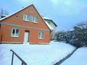 a red house with snow in front of it at Chata Elča in Lipova Lazne