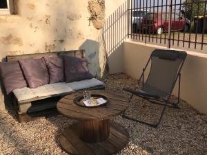 ein Wohnzimmer mit einem Sofa, einem Tisch und einem Stuhl in der Unterkunft La cavée du coteau, petit cocon troglodytique in Vouvray