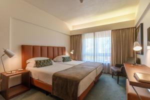 a hotel room with a large bed and a window at Hotel Dom Goncalo & Spa in Fátima