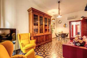 ローマにあるNavona Stylish Apartmentのリビングルーム(黄色い椅子、キャビネット付)