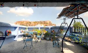 a balcony with a table and chairs on a roof at Cosy Guest House in Jodhpur