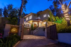ein Haus mit einem Tor davor bei Nacht in der Unterkunft StayVista's Chimney Cottage with Sprawling Lawns, Picturesque Views, Plunge Pool, Jacuzzi, and Home Theatre in Panchgani