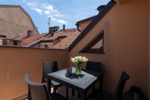 a table on a balcony with a vase of flowers at Bohemian Dreams Apartments and Suites in Prague
