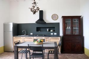 a kitchen with a table with chairs and a refrigerator at Agriturismo Morani in Santa Severa