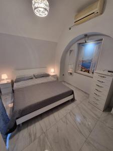 a white bedroom with a bed and a window at Casa Gio’ in Naples