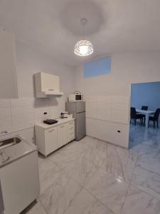 a kitchen with white appliances and a table in it at Casa Gio’ in Naples