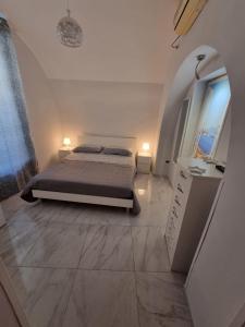 a white bedroom with a bed and a window at Casa Gio’ in Naples