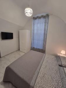 una camera con un grande letto e una televisione di Casa Gio’ a Napoli
