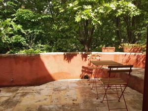 een groep tafels en stoelen op een patio bij maison au coeur de Fontaine de Vaucluse, nichée sur le rocher et surplombant la sorgue in Fontaine-de-Vaucluse