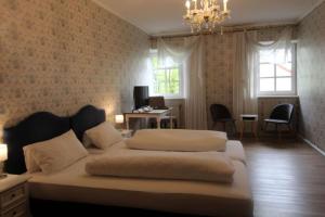 a bedroom with two beds and a desk and windows at Hotel-Gasthof Opel in Heinersreuth