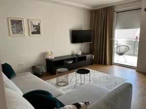 - un salon avec un canapé et une télévision dans l'établissement Central apartment/free parking/free wifi, à Imotski