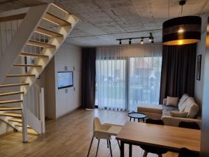 Una sala de estar con una escalera y un sofá. en Domki Gold-Time Niechorze, en Niechorze